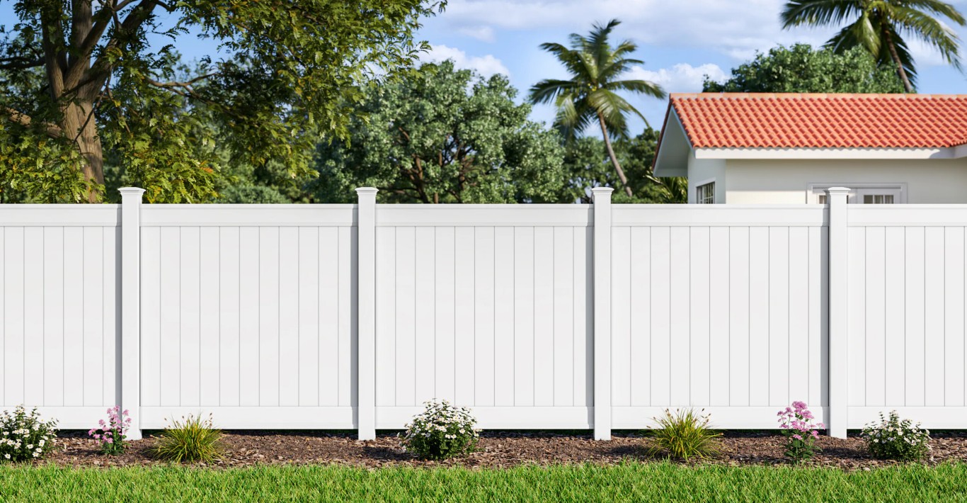 Beautiful white vinyl fence installed in front of home with landscaping
